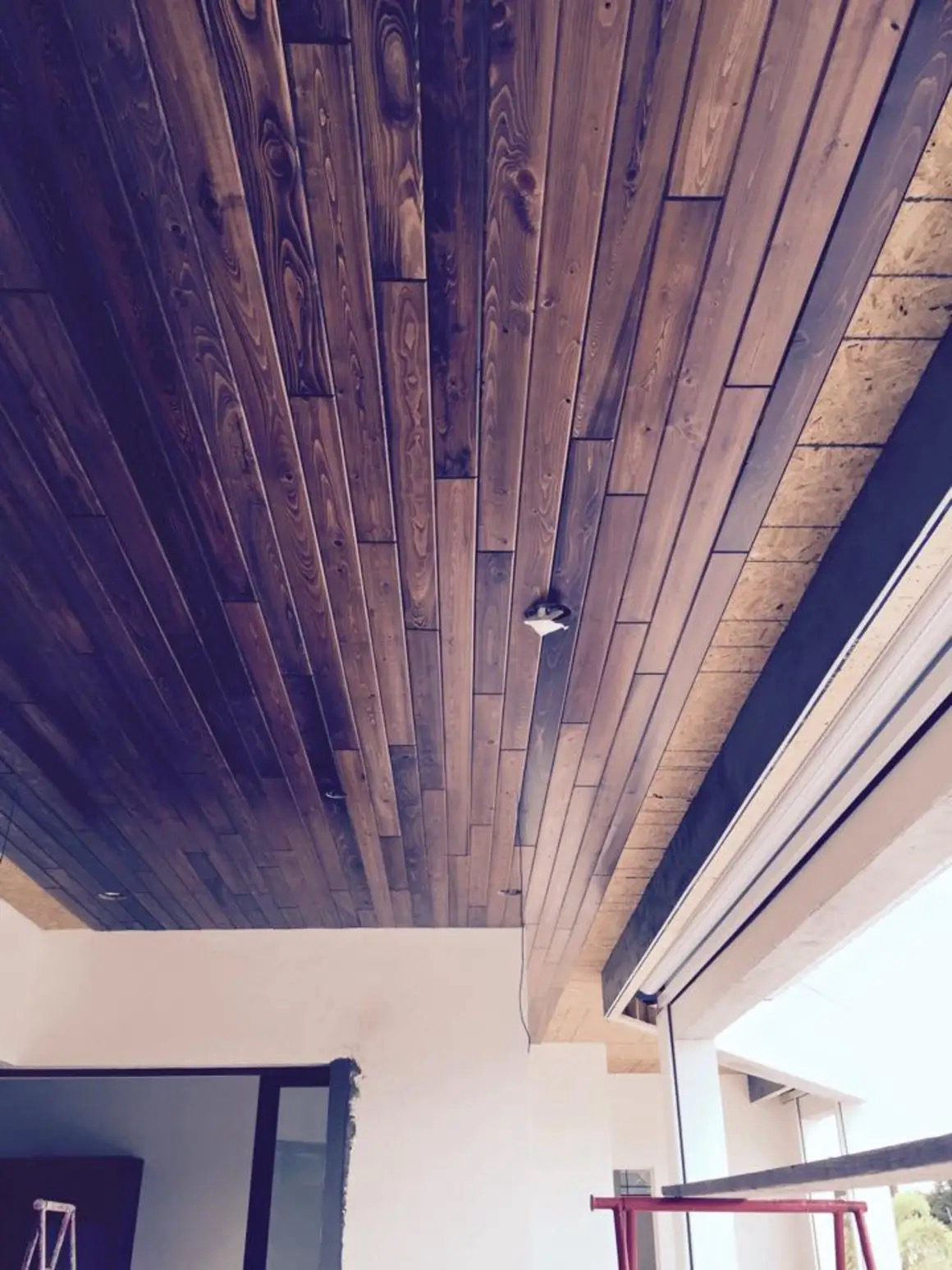 Stained tongue-and-groove wood ceiling installed by Thorn Fine Finishes